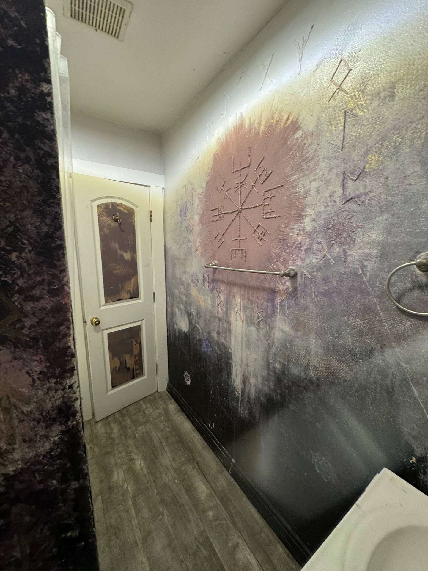 Finished raised wall art in context with door, towel bar, and bathroom fixtures